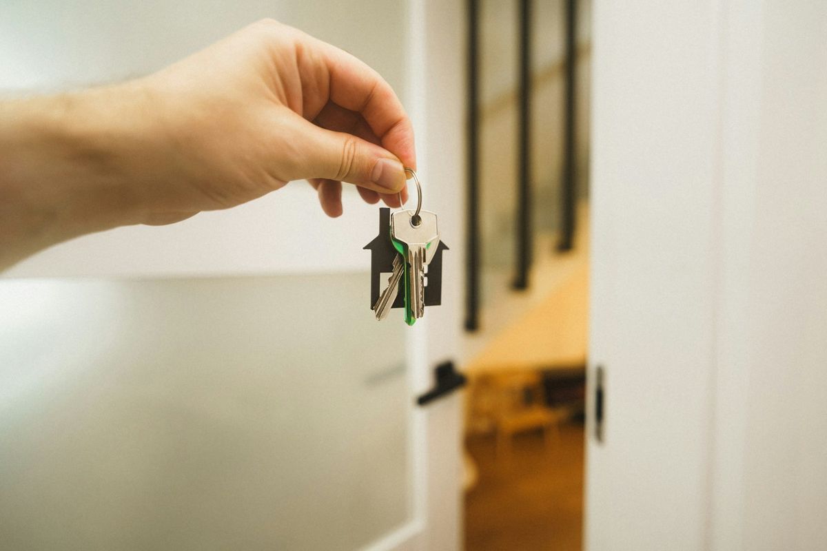 Hånd som holder en nøkkel til en dør – boliglån