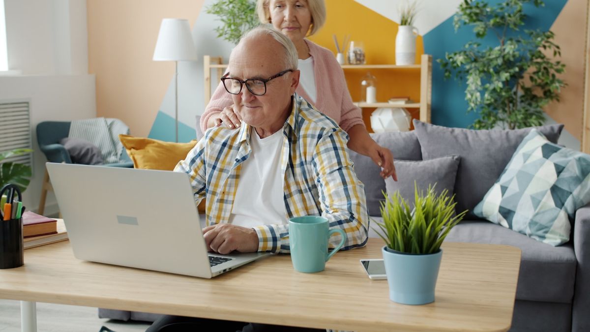 Eldre par bruker laptop sammen – kausjon i familien