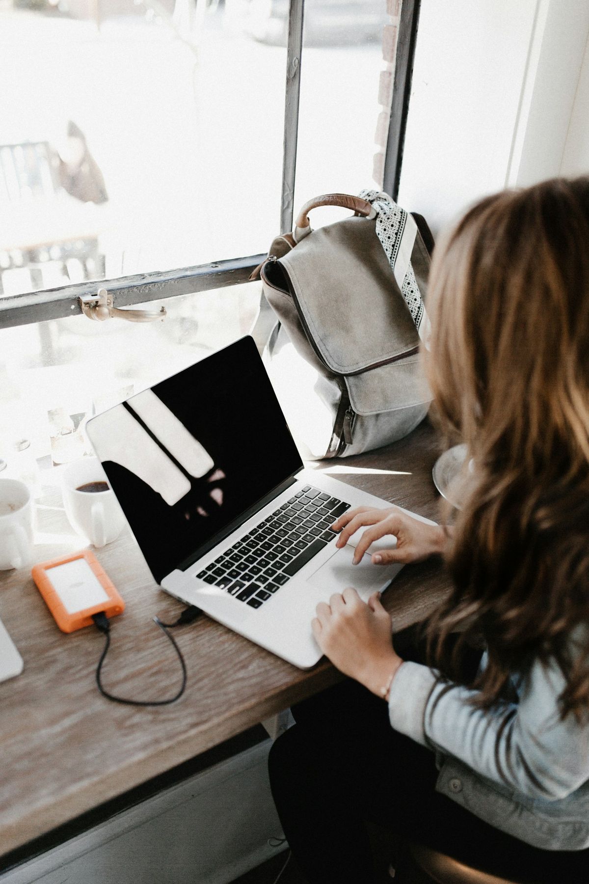 Student som jobber med laptop ved skrivebord